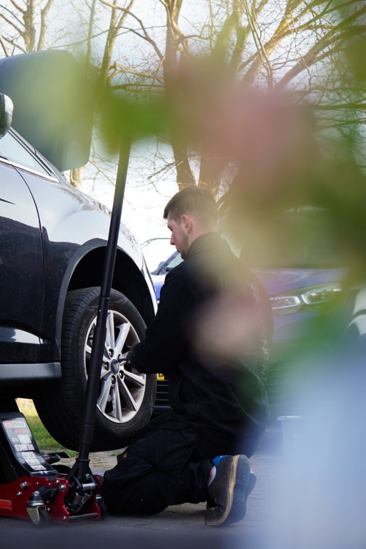 BoxNow mekaniker monterer hjul hos kunde som en del af bilservice på hjemmeadressen